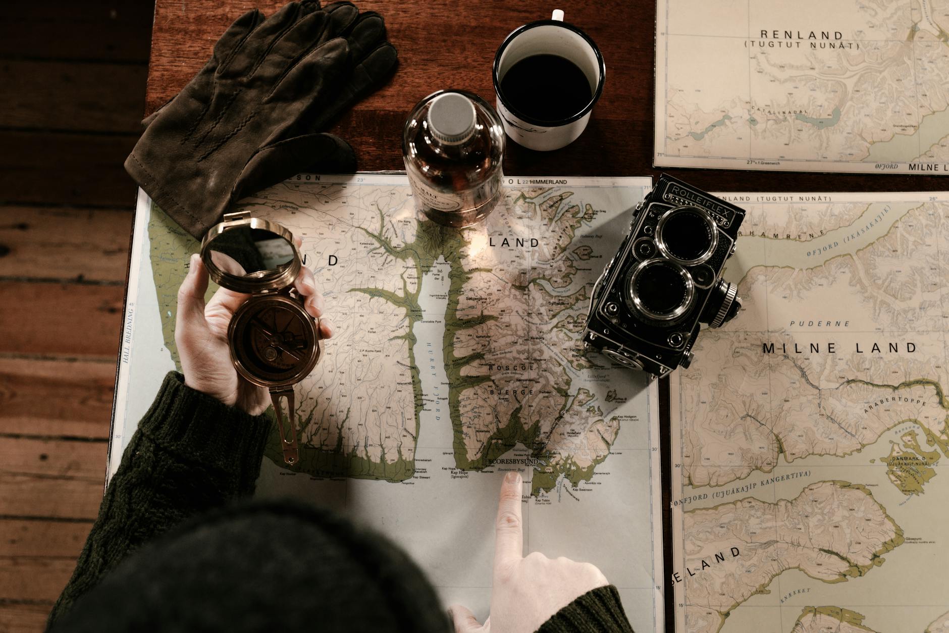 man looking at a map and holding a vintage compass