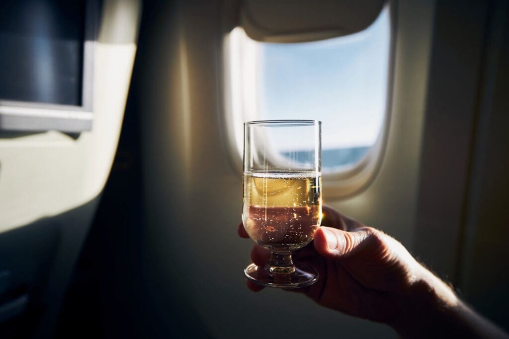 Glass of champagne served during a flight beside an airplane window