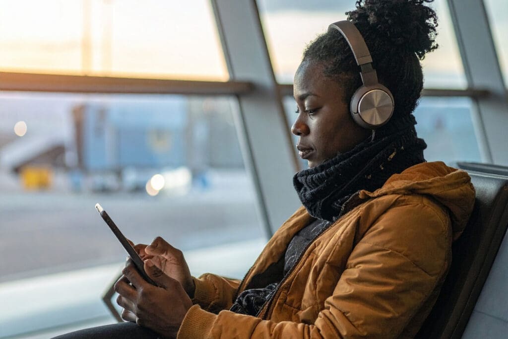 Traveler wearing headphones for calm at the airport before a flight