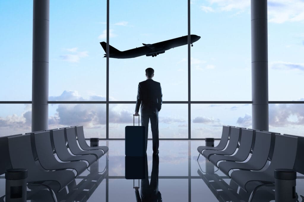 International traveler with luggage looking toward aircraft illustrating emergency travel support and evacuation coverage