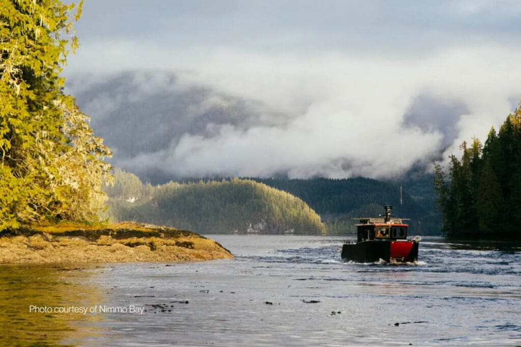Boat traveling through the remote coastal wilderness surrounding Nimmo Bay in British Columbia