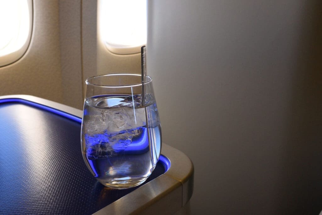 Glass of water on an airplane tray table during a flight