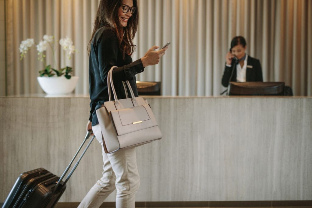Traveler using a phone while checking into a hotel during an international trip