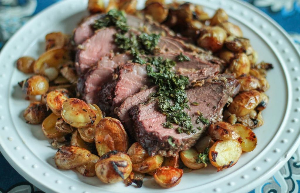 Roast lamb served with mint sauce and roasted potatoes