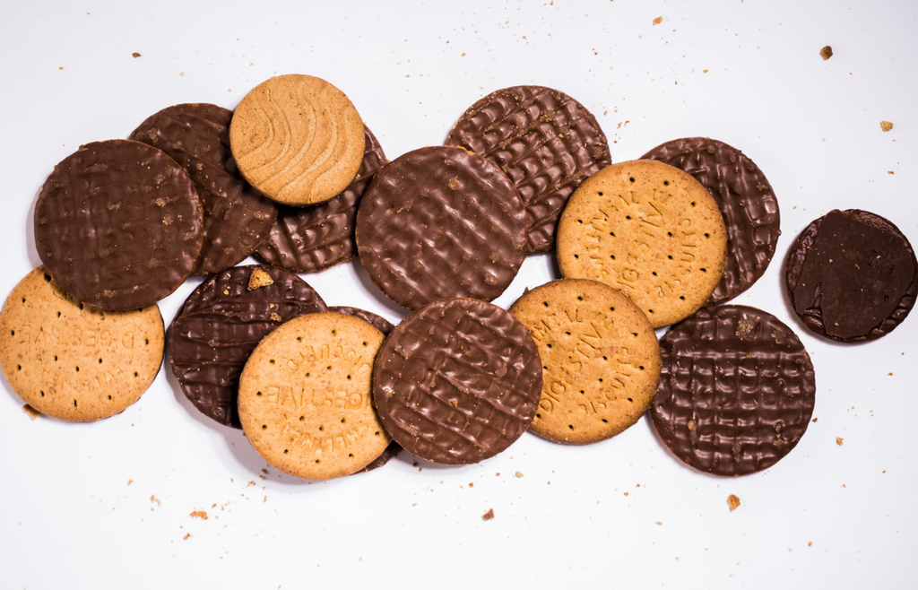 Plain and chocolate digestive biscuits scattered on a white background